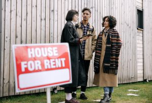 An interracial couple meets with a real estate agent to inquire about a house for rent.